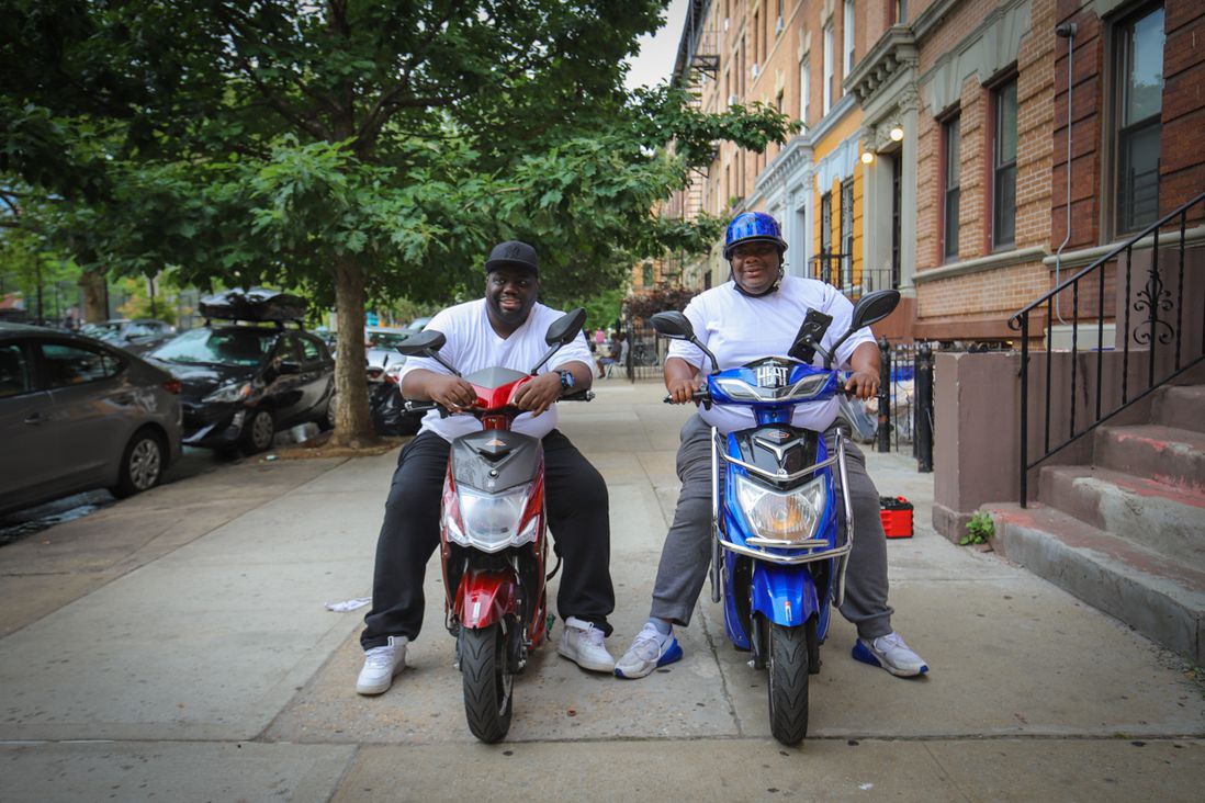 A photo of two people on motorcycles on sidewalk in Crown Heights